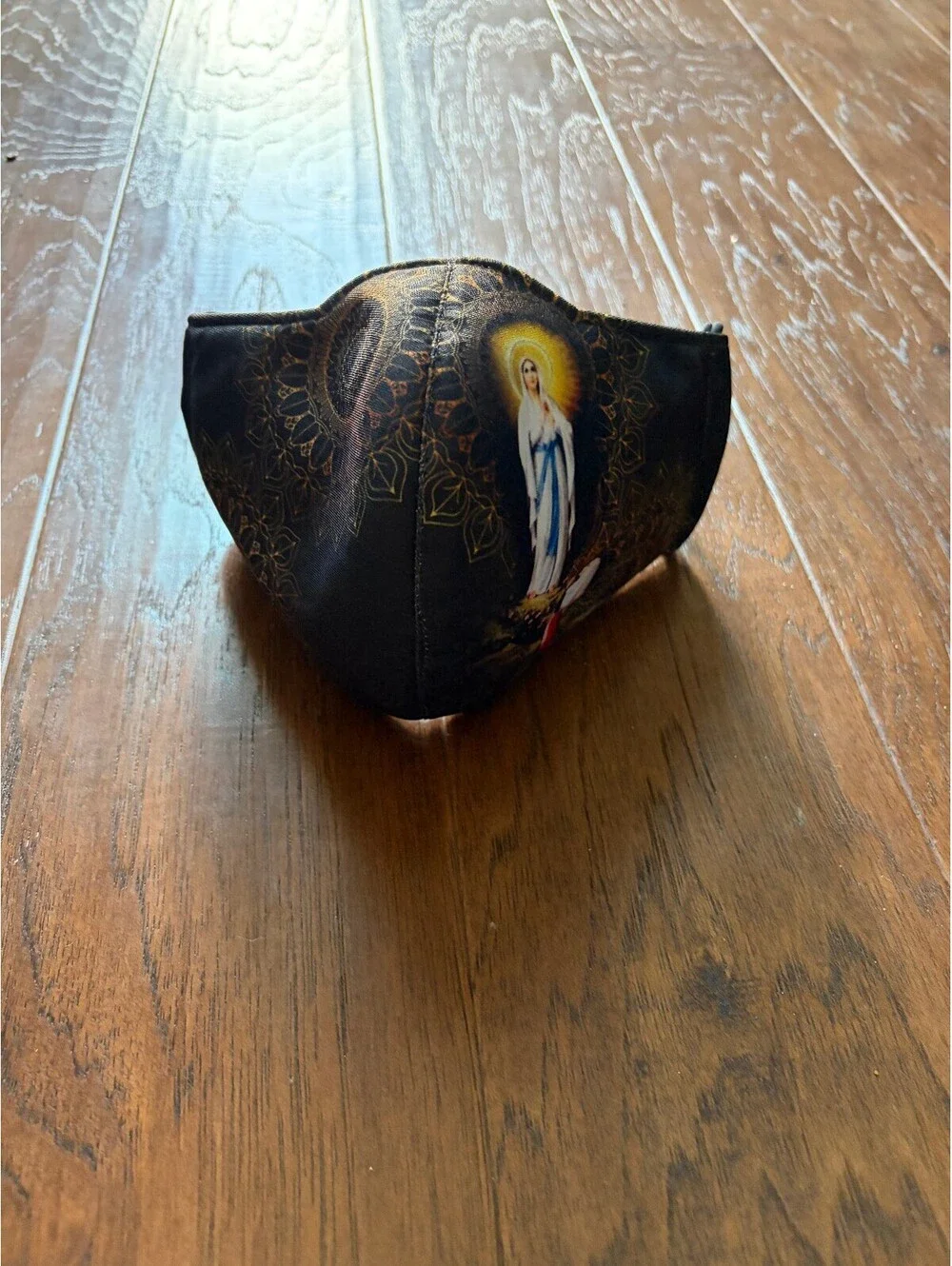 Black Face Mask with Religious Artwork and Decorative Pattern